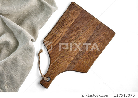 beige wooden cutting board and crumpled linen tablecloth isolated on white background 127513079