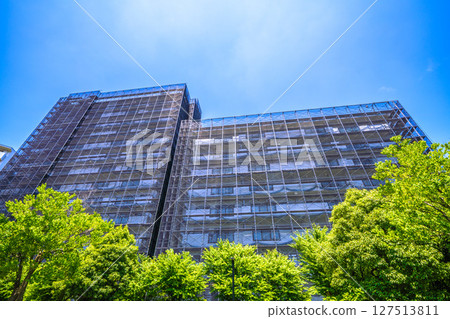 Yokohama cityscape in Japan. Apartment building repairs and inspections, scaffolding and protective nets. Satellite antennas outside the nets... 127513811