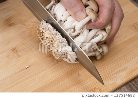Steps for making mushroom rice: Cut off the stems of the shimeji mushrooms Steps for making mushroom rice: Cut off the stems of the shimeji mushrooms 127514698