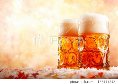 Enjoying foamy beer in large glass goblets during Oktoberfest celebration in a festive atmosphere Enjoying foamy beer in large glass goblets during Oktoberfest celebration in a festive atmosphere 127514852