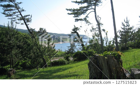 A view of the blue sea and green foothills from the cape on a clear summer day A view of the blue sea and green foothills from the cape on a clear summer day 127515823