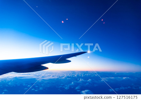 從飛機內部看到的日出天空和飛機機翼 127516175