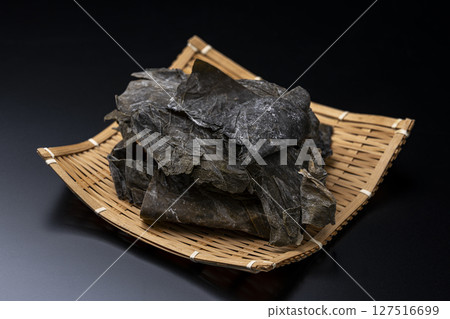 Rausu kelp served on a bamboo sieve on a black background 127516699