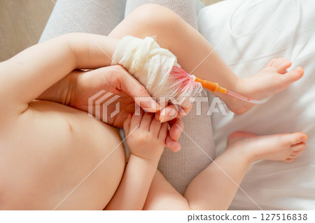 baby in hospital with intravenous saline. Sick children, are lying and being treated in beds in hospitals. baby in hospital with intravenous saline. Sick children, are lying and being treated in beds in hospitals. 127516838