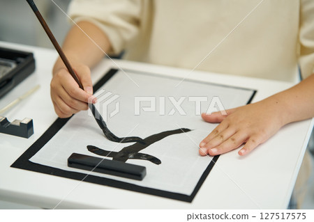 Elementary school students taking calligraphy lessons 127517575