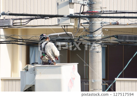 一名男子在升降車上進行接線工作 127517594