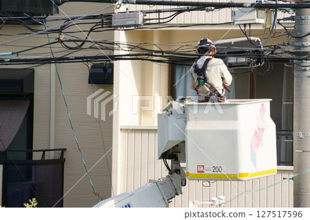 一名男子正在駕駛高空作業車進行佈線工作 127517596