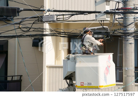 一名男子在高空作業車上進行電氣工作 127517597