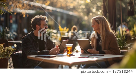 a man and woman collaborating on a project in an urban park coworking space, stylish outdoor furniture and public Wi Fi area visible, blank right side for text, bright clear light 127518244