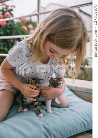 Young girl enjoys playful moments with kittens on a sunny afternoon outdoors Young girl enjoys playful moments with kittens on a sunny afternoon outdoors 127518670