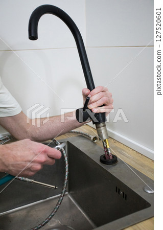 Plumber repair water tap in kitchen. Repair service concept. 127520601