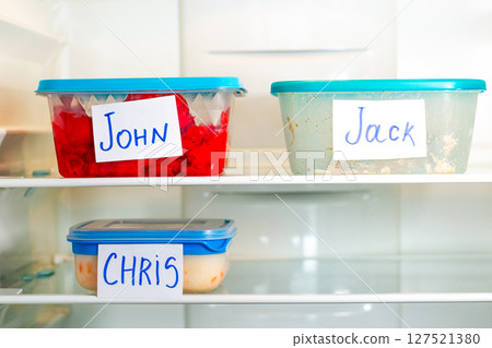 Office lunch containers with handwritten name stickers in shared fridge. Healthy food preparation for work office study. Office lunch containers with handwritten name stickers in shared fridge. Healthy food preparation for work office study. 127521380