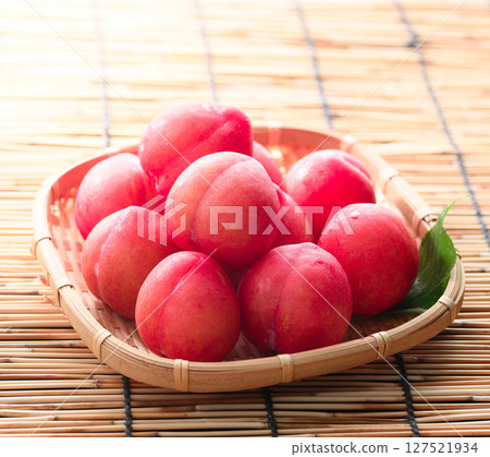 Early plums arranged in a basket 127521934