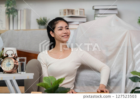 Moving and Settling. Woman sitting comfortably in her new home, smiling. 127523503