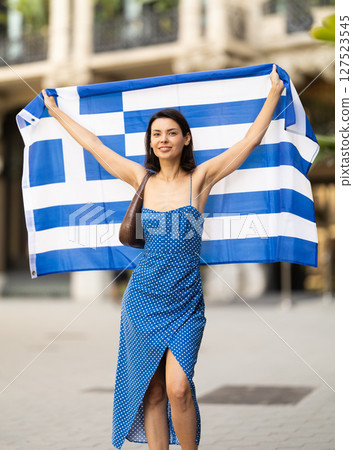 Young woman with Greek flag on city street 127523545