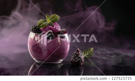 Rich berry ice cream served in a glass with mint and blackberries, surrounded by atmospheric purple fog and dramatic lighting.  127523735