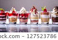 Colorful assortment of layered dessert shooters in glass cups, featuring mousse, cream, fruit, and toppings in elegant presentation.  127523786