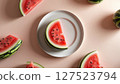 Fresh watermelon slices arranged on a white plate with whole pieces on soft pink background, symbolizing summer refreshment.  127523794