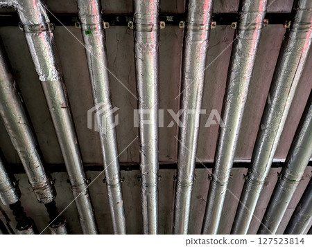 Industrial Metal Pipes on the Walls in a Car Park Building 127523814