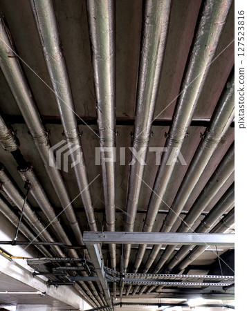 Industrial Metal Pipes on the Walls in a Car Park Building 127523816