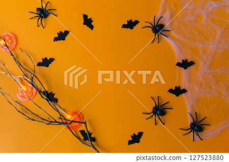 Halloween decorations with pumpkins, bats, web, bugs on orange background. Party greeting card with copy space.  127523880
