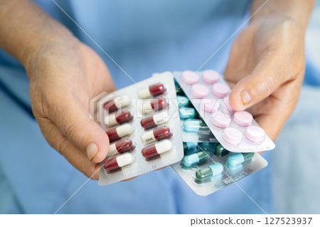 Asian elderly woman patient holding drug in her hand, healthy strong medical concept. Asian elderly woman patient holding drug in her hand, healthy strong medical concept. 127523937