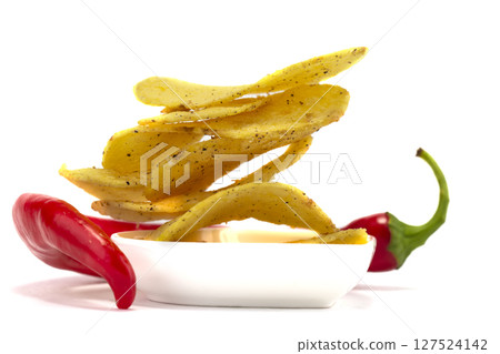 Potato chips with chili peppers on a white background. 127524142