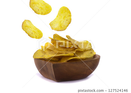 Chips are flying into a wooden plate on a white background. 127524146