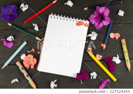 Paper notebook with blank pages, crumpled paper balls and colored pencils on wooden background, creative writing concept. A minimalist workplace for a writer or artist. Creative torment. Paper notebook with blank pages, crumpled paper balls and colored pencils on wooden background, creative writing concept. A minimalist workplace for a writer or artist. Creative torment. 127524243