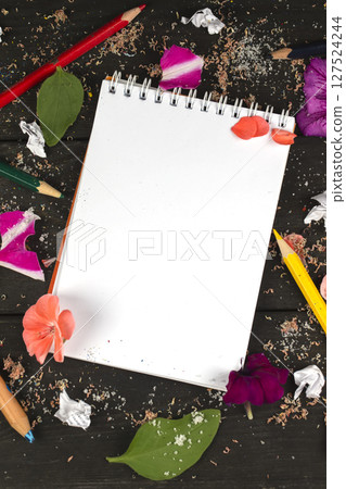 Paper notebook with blank pages, crumpled paper balls and colored pencils on wooden background, creative writing concept. A minimalist workplace for a writer or artist. Creative torment. Paper notebook with blank pages, crumpled paper balls and colored pencils on wooden background, creative writing concept. A minimalist workplace for a writer or artist. Creative torment. 127524244