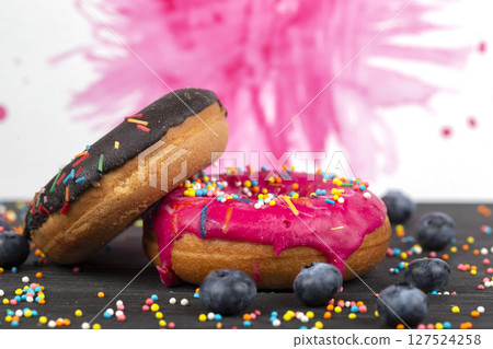Creative sweet food. Bright donuts with multi-colored sprinkles on a colorful background. Creative sweet food. Bright donuts with multi-colored sprinkles on a colorful background. 127524258