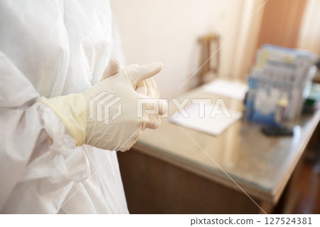 Doctor's hands in rubber gloves on the background of the office Doctor's hands in rubber gloves on the background of the office 127524381