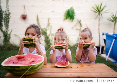 Enjoying summer bliss with watermelon slices in the backyard 127524637