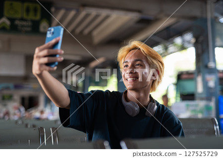 Young Asian tourist man in bus station Young Asian tourist man in bus station 127525729