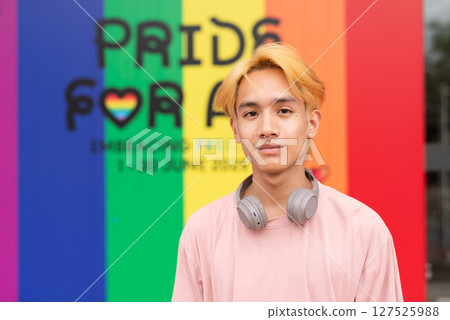 Handsome gay man portrait against pride rainbow background Handsome gay man portrait against pride rainbow background 127525988