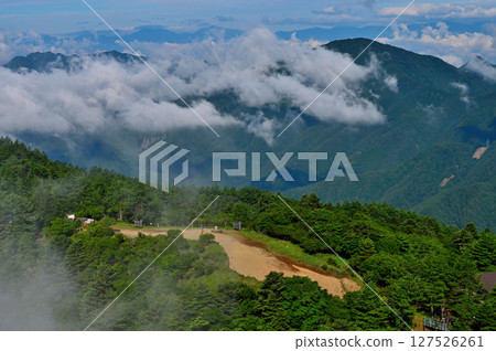 View of Mt. Kurodake between the clouds from the summit of Mt. Mitsutoge in the Misaka Mountains View of Mt. Kurodake between the clouds from the summit of Mt. Mitsutoge in the Misaka Mountains 127526261