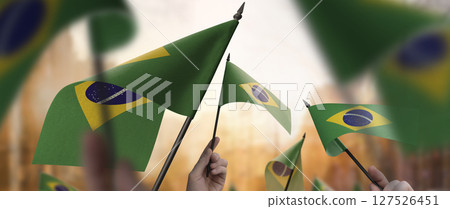 Brazil flags in their hands on a blurred urban background Brazil flags in their hands on a blurred urban background 127526451