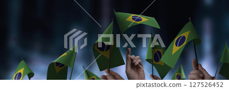 Brazil flags in their hands on a blurred urban background Brazil flags in their hands on a blurred urban background 127526452