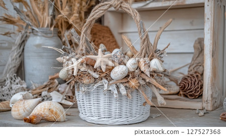 Coastal style beach house decoration featuring woven basket filled with seashells and driftwood at seaside retreat 127527368