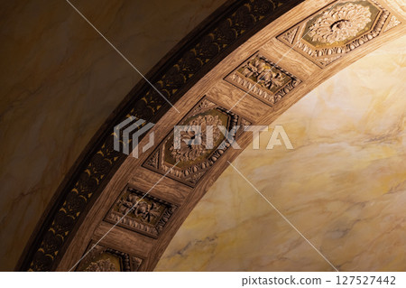 A close-up view of an ornately designed arch, classic interior details 127527442