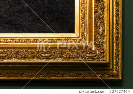 Detailed close-up view of an ornate gold-gilded frame Detailed close-up view of an ornate gold-gilded frame 127527454