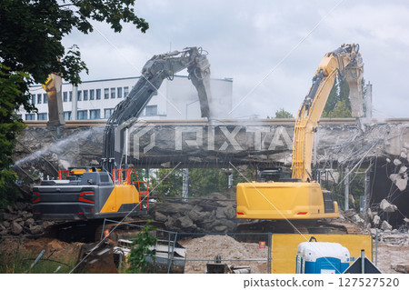 Close-up view of crumbling bridge structure demolition in Magdeburg Damaschkeplatz  exposed steel rebar falling concrete chunks. Rubble piles and demolition machinery emphasize destruction progress 127527520