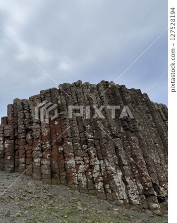 Giant's Causeway is a UNESCO World Heritage Site on Northern Ireland's Antrim Coast, famous for hexagonal stones by volcanic activity and beautiful coast. 127528194
