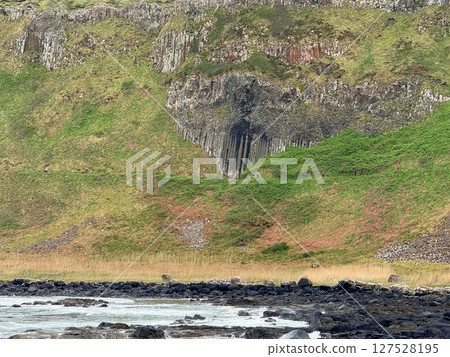Giant's Causeway is a UNESCO World Heritage Site on Northern Ireland's Antrim Coast, famous for hexagonal stones by volcanic activity and beautiful coast. 127528195