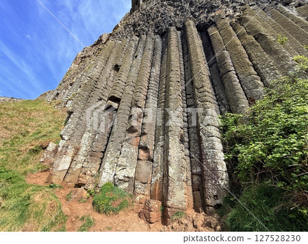Giant's Causeway is a UNESCO World Heritage Site on Northern Ireland's Antrim Coast, famous for hexagonal stones by volcanic activity and beautiful coast. 127528230
