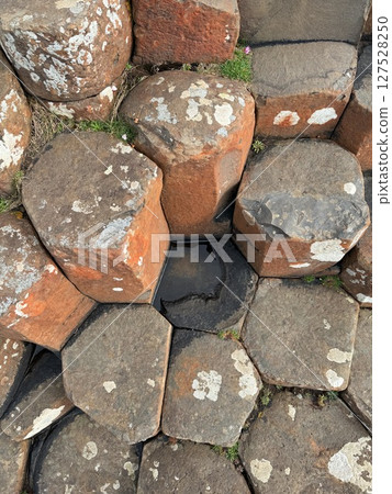 Giant's Causeway is a UNESCO World Heritage Site on Northern Ireland's Antrim Coast, famous for hexagonal stones by volcanic activity and beautiful coast. 127528250