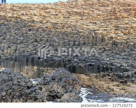 Giant's Causeway is a UNESCO World Heritage Site on Northern Ireland's Antrim Coast, famous for hexagonal stones by volcanic activity and beautiful coast. 127528272