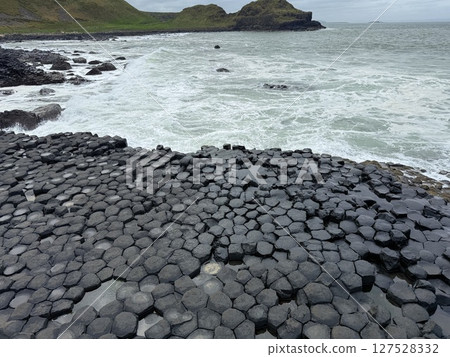 Giant's Causeway is a UNESCO World Heritage Site on Northern Ireland's Antrim Coast, famous for hexagonal stones by volcanic activity and beautiful coast. 127528332