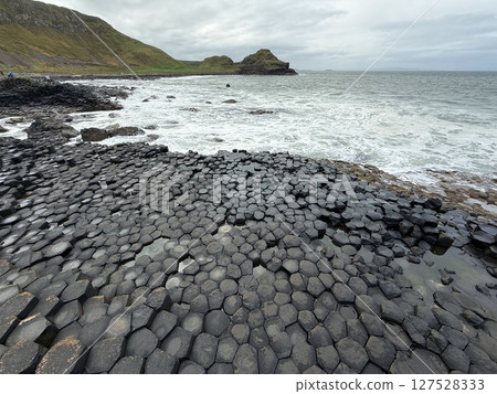 Giant's Causeway is a UNESCO World Heritage Site on Northern Ireland's Antrim Coast, famous for hexagonal stones by volcanic activity and beautiful coast. 127528333