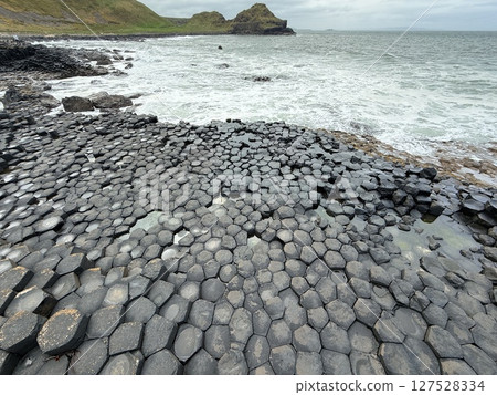 Giant's Causeway is a UNESCO World Heritage Site on Northern Ireland's Antrim Coast, famous for hexagonal stones by volcanic activity and beautiful coast. 127528334